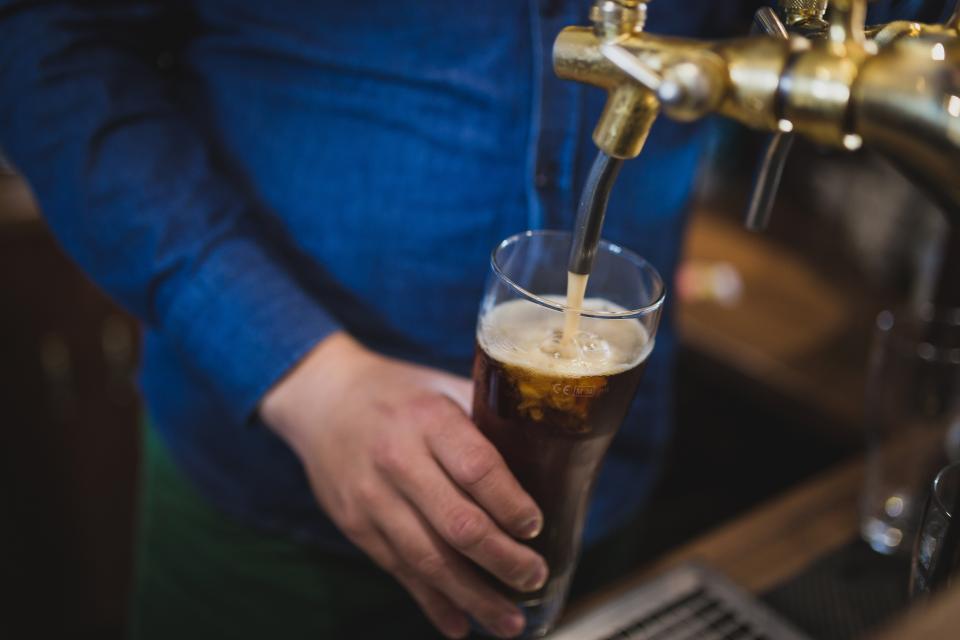 Birra scura versata dalla spina in un bicchiere