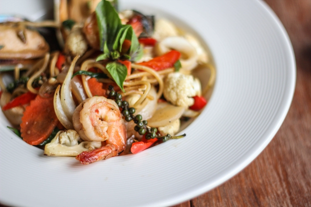 Spaghetti con frutti di mare e gamberi in un piatto bianco